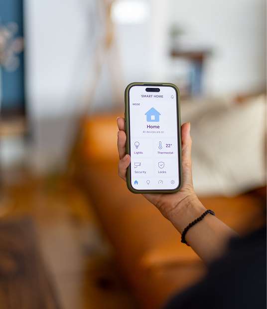 Main d'une personne contrôlant la domotique de sa maison via une application sur smartphone, installateur domotique Degee
