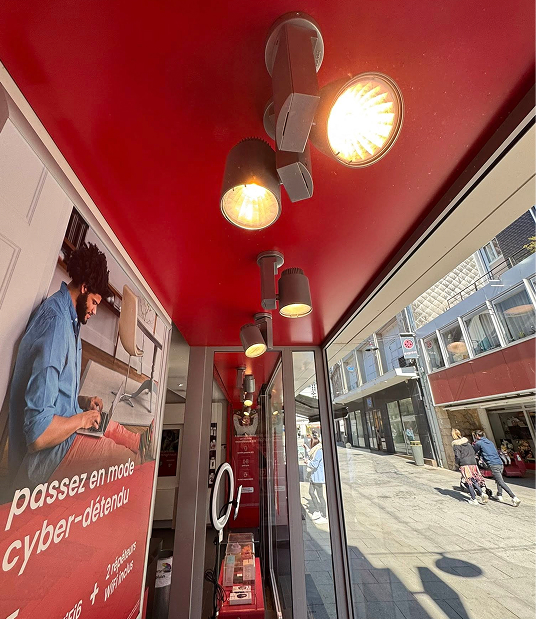 Installation électrique avec spots lumineux au plafond rouge d'un magasin, visible de l'extérieur d'une enseigne à Rouen